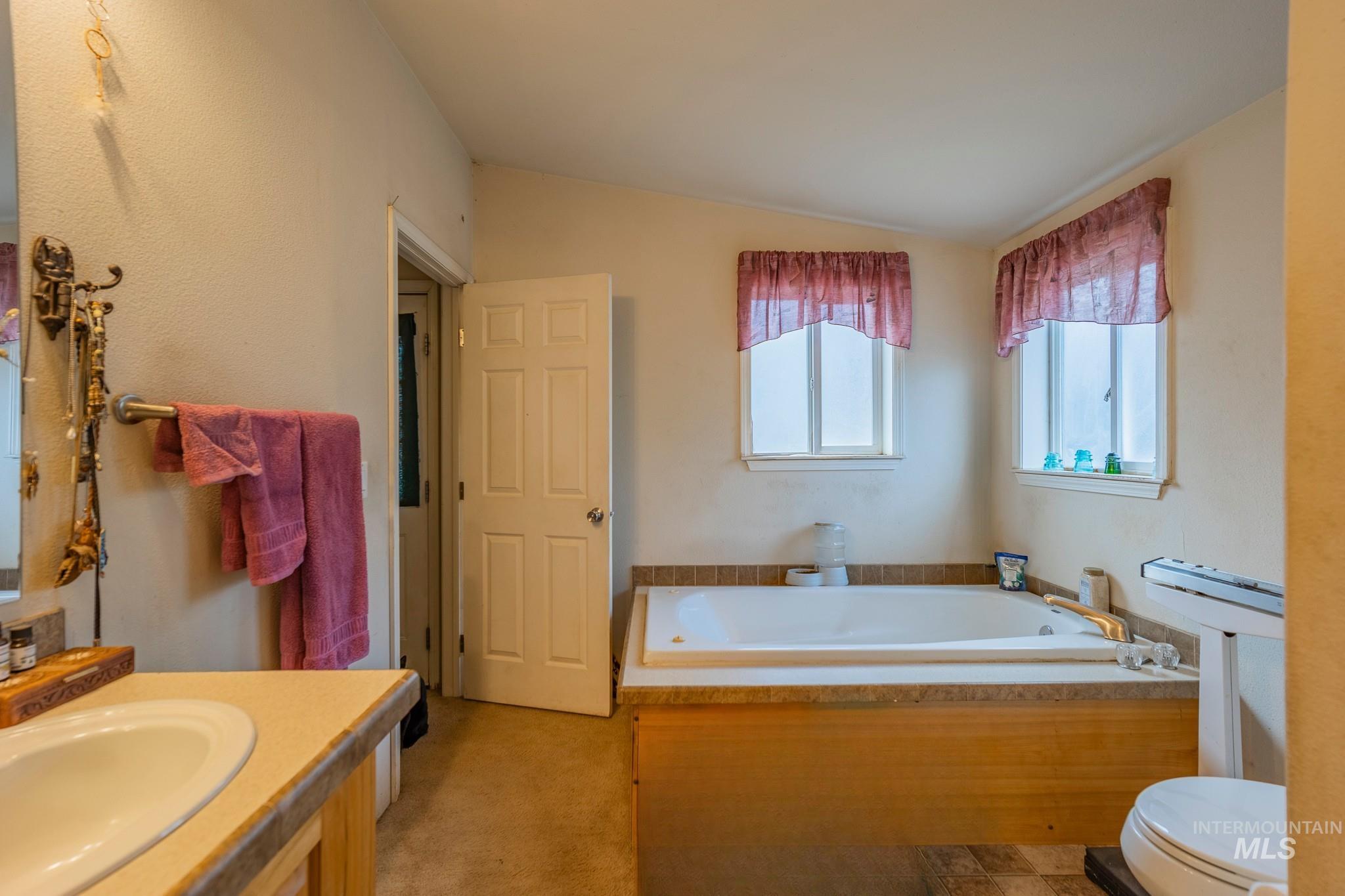 3608 Highway 13 Stites, ID 83552 - Photo 30 of 44 Bathroom featuring a bath, vaulted ceiling, and vanity