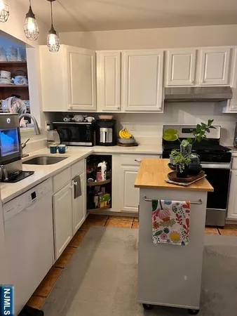 a kitchen with stainless steel appliances a table and chairs