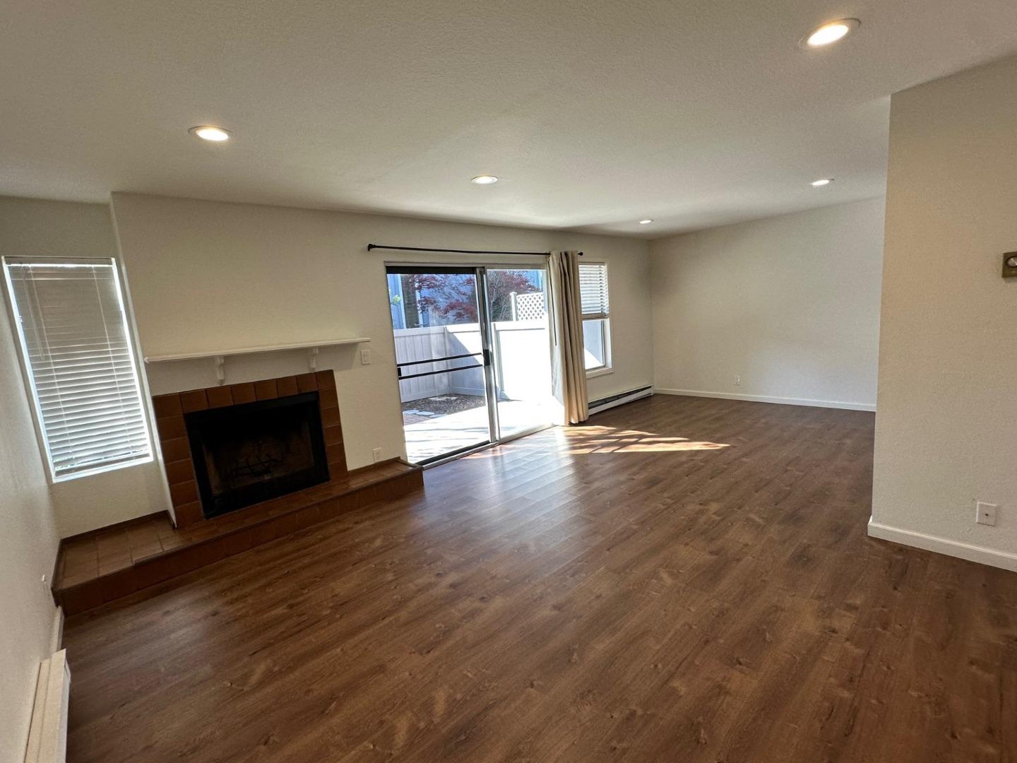 2212 Almaden Road, Unit A San Jose, CA 95125 - Photo 6 of 15 an empty room with wooden floor fireplace and windows