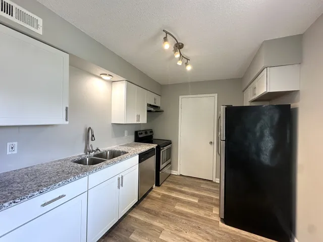 a kitchen with a refrigerator and a sink