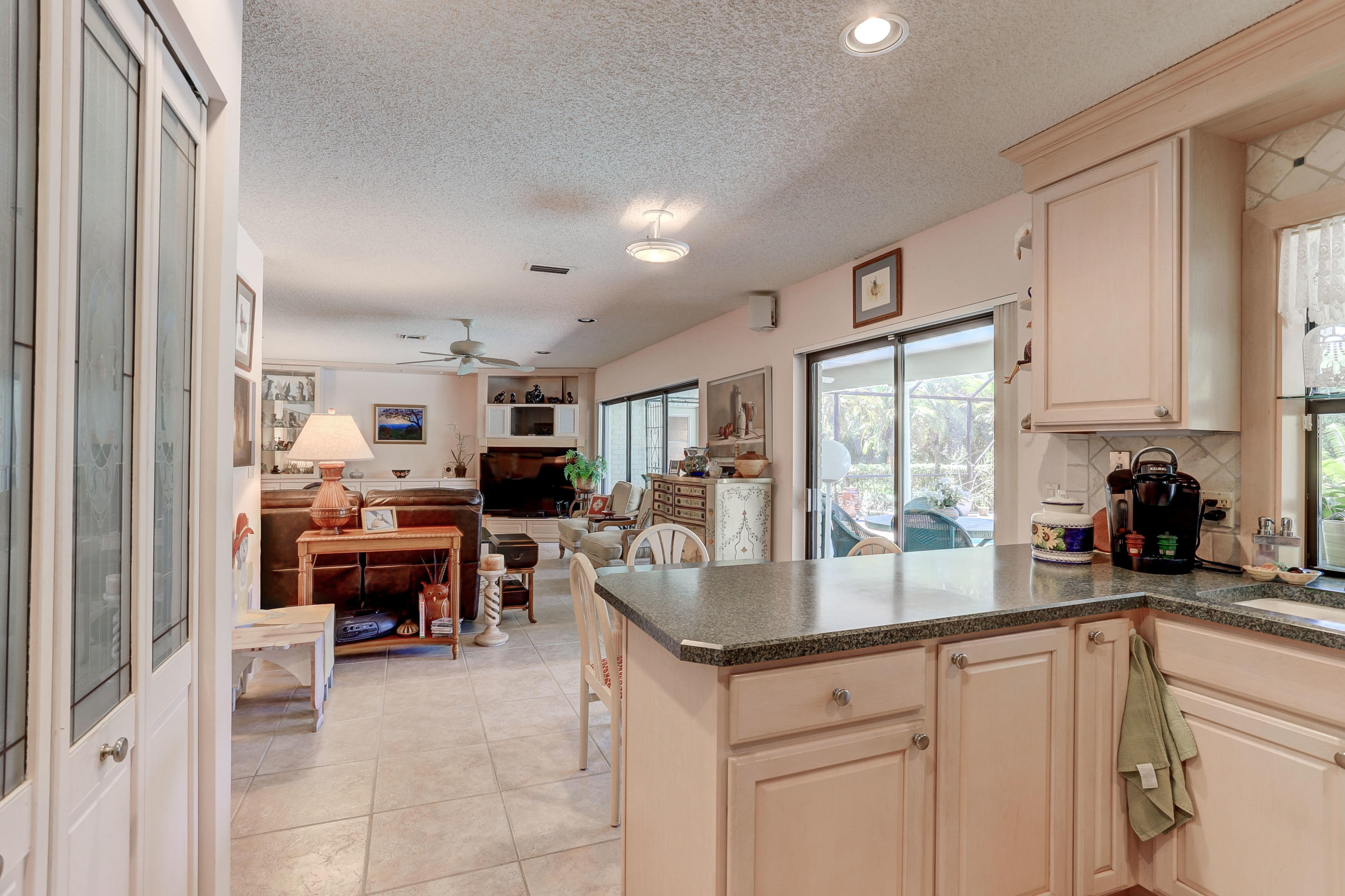 6835 Viento Way Boca Raton, FL 33433 - Photo 17 of 43 a kitchen with sink refrigerator and dining table