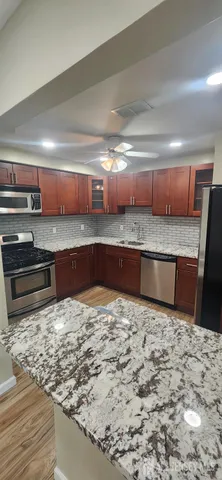 a kitchen with stainless steel appliances kitchen island granite countertop a sink and cabinets