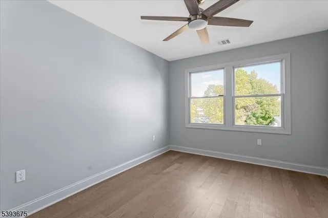 an empty room with a window and a fan