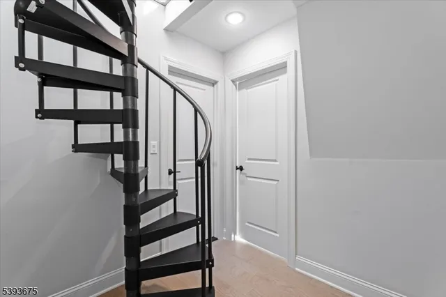 a view of staircase with lots of frames on wall and a potted plant