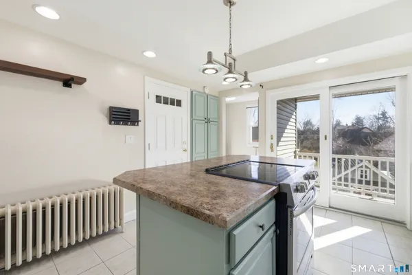 a living room with stainless steel appliances granite countertop furniture and a chandelier