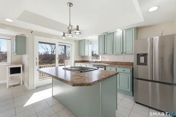 a kitchen with stainless steel appliances granite countertop a refrigerator a sink a stove and a refrigerator