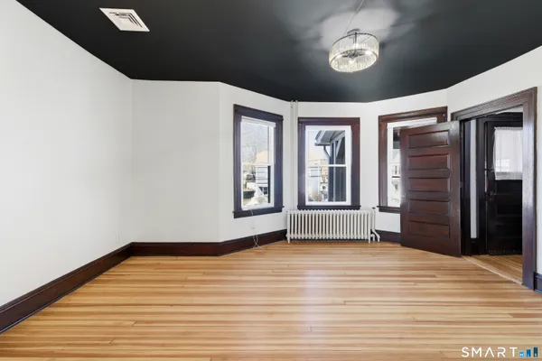 a view of empty room with wooden floor