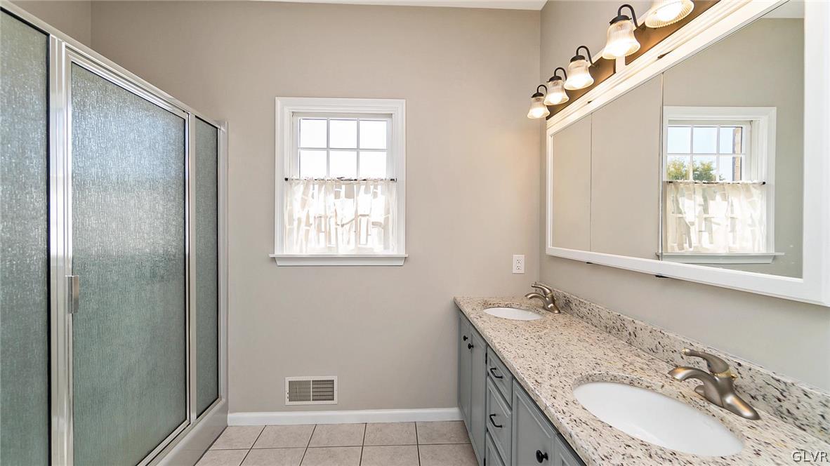 573 West Moorestown Road Nazareth, PA 18064 - Photo 22 of 46 a bathroom with a granite countertop double vanity sink a mirror and a shower