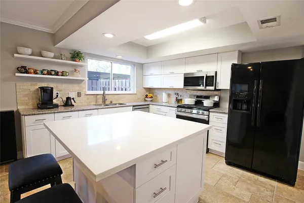 a kitchen with stainless steel appliances a refrigerator sink and microwave