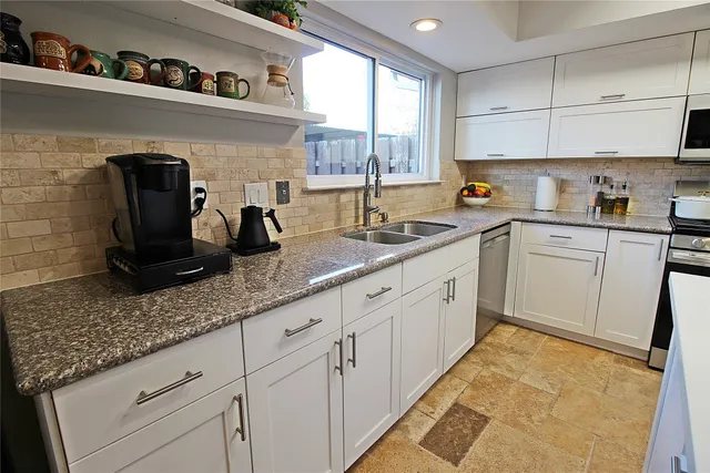 a kitchen with granite countertop white cabinets and white appliances
