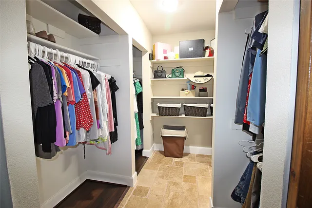 a view of walk in closet with clothes and shoes