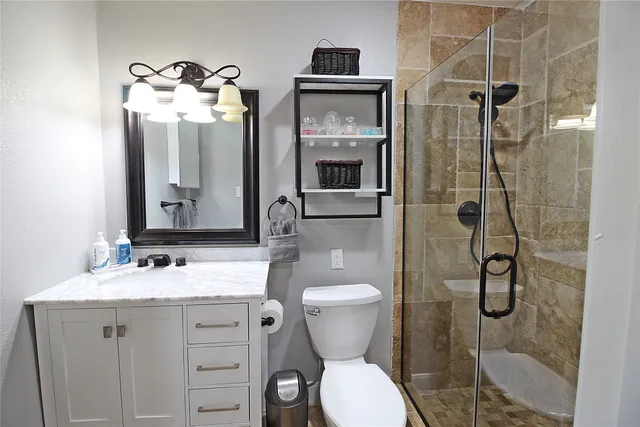 a bathroom with a granite countertop sink toilet and shower