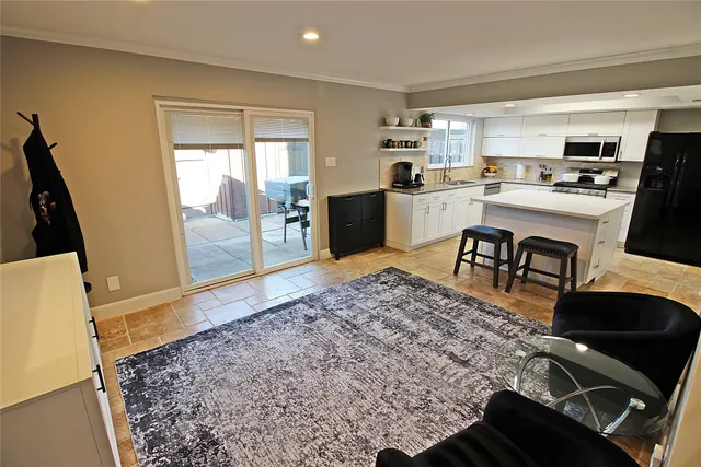 a living room with stainless steel appliances furniture and a rug