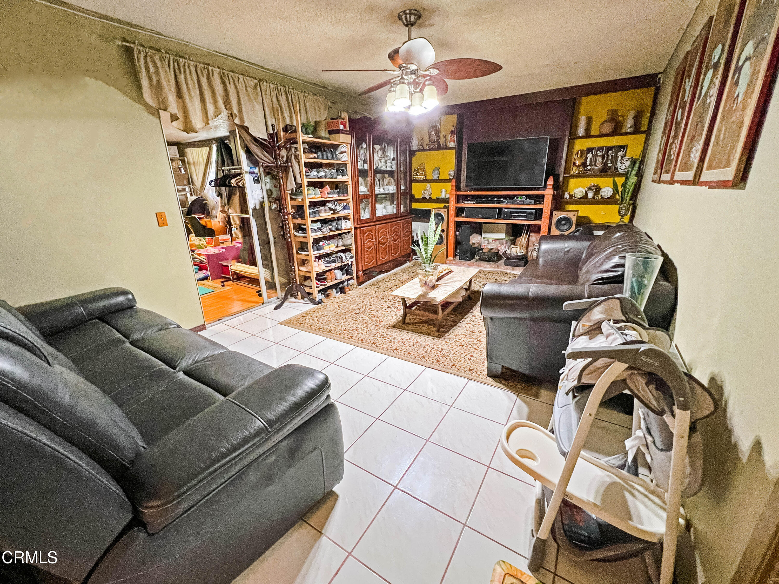 5001 Ivan Drive Oxnard, CA 93033 - Photo 5 of 16 a living room with furniture a flat screen tv and gym equipment