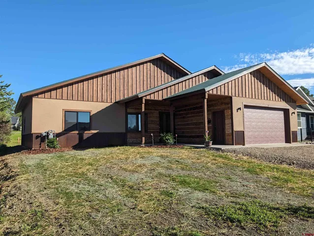 a view of a house with yard and sitting area