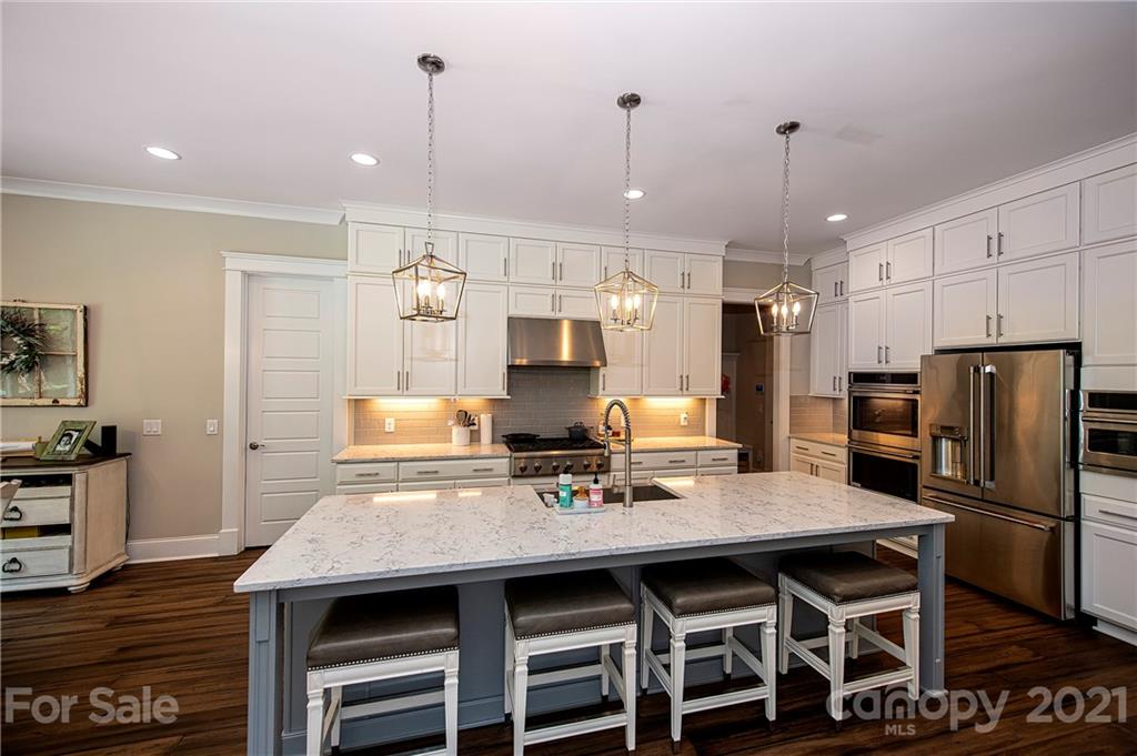 1286 Trinity Ridge Parkway Fort Mill, SC 29715 - Photo 19 of 48 a kitchen with granite countertop a table chairs stainless steel appliances and wooden floor
