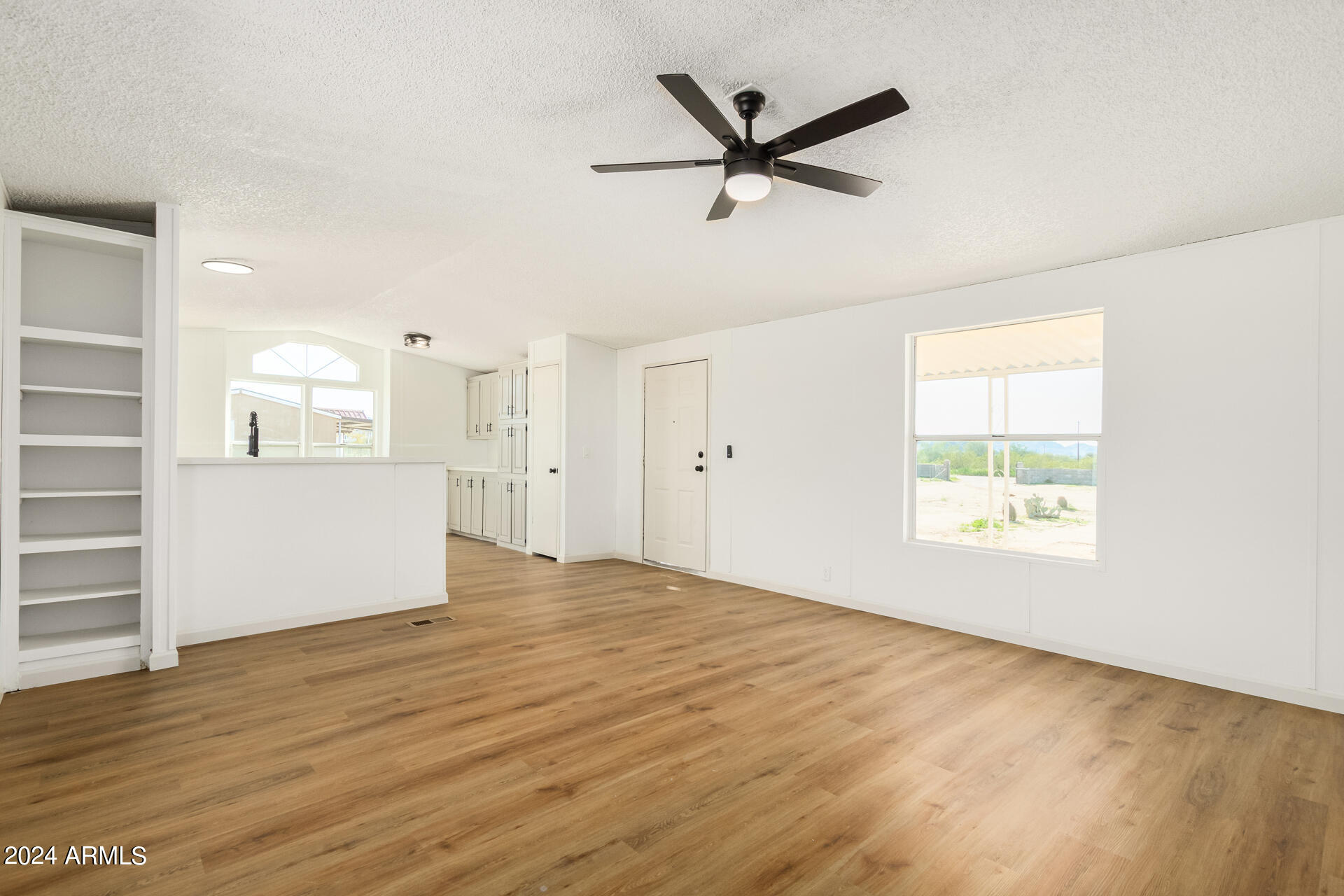 355 North Conejo Road Maricopa, AZ 85139 - Photo 4 of 30 wooden floor in an empty room with a window