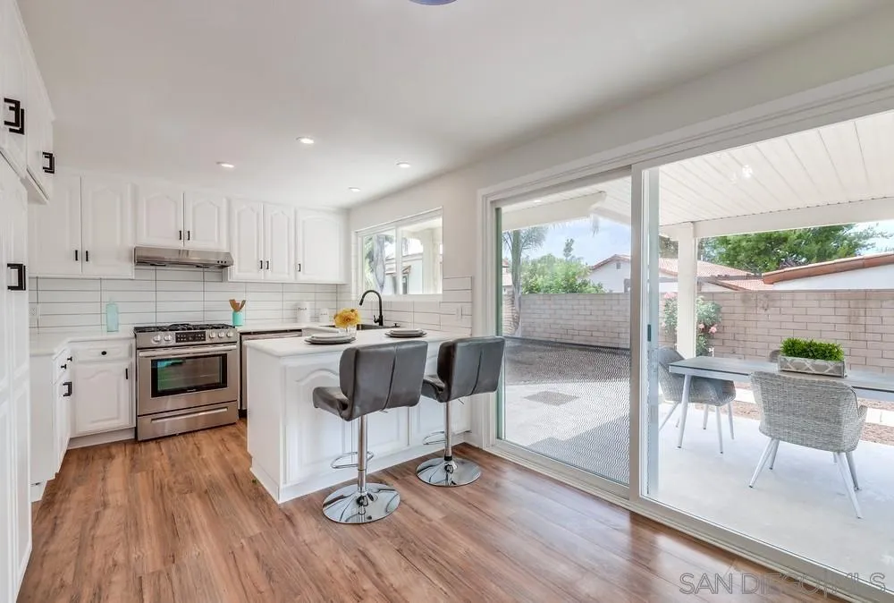 13362 Carriage Road Poway, CA 92064 - Photo 11 of 39 a kitchen with a table chairs refrigerator and cabinets