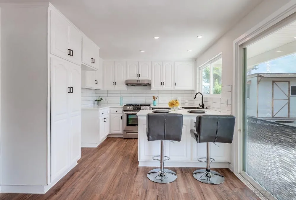 13362 Carriage Road Poway, CA 92064 - Photo 12 of 39 a kitchen with stainless steel appliances wooden floor dining table and chairs