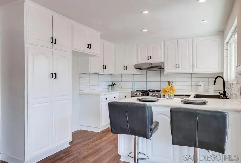 13362 Carriage Road Poway, CA 92064 - Photo 13 of 39 a kitchen with stainless steel appliances granite countertop a stove a sink a refrigerator and white cabinets