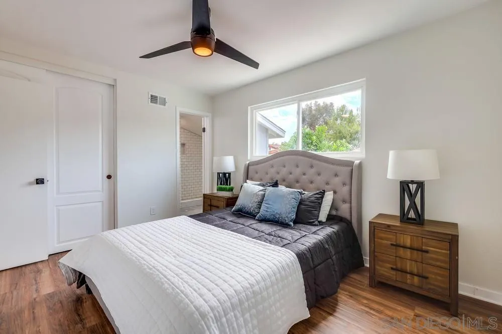 13362 Carriage Road Poway, CA 92064 - Photo 19 of 39 a bedroom with a large bed and a lamp on dresser