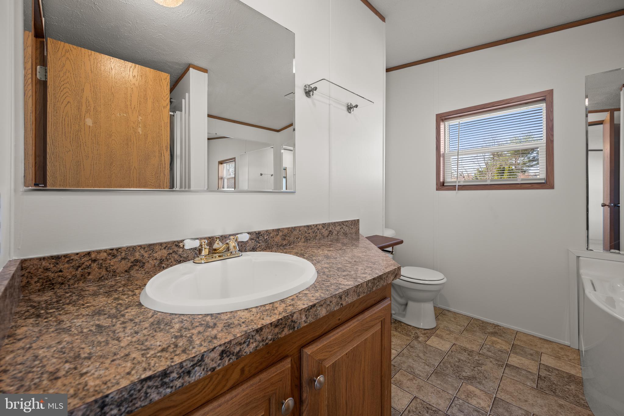 8408 Heartwood Road Jessup, MD 20794 - Photo 21 of 32 a bathroom with a granite countertop sink and a mirror