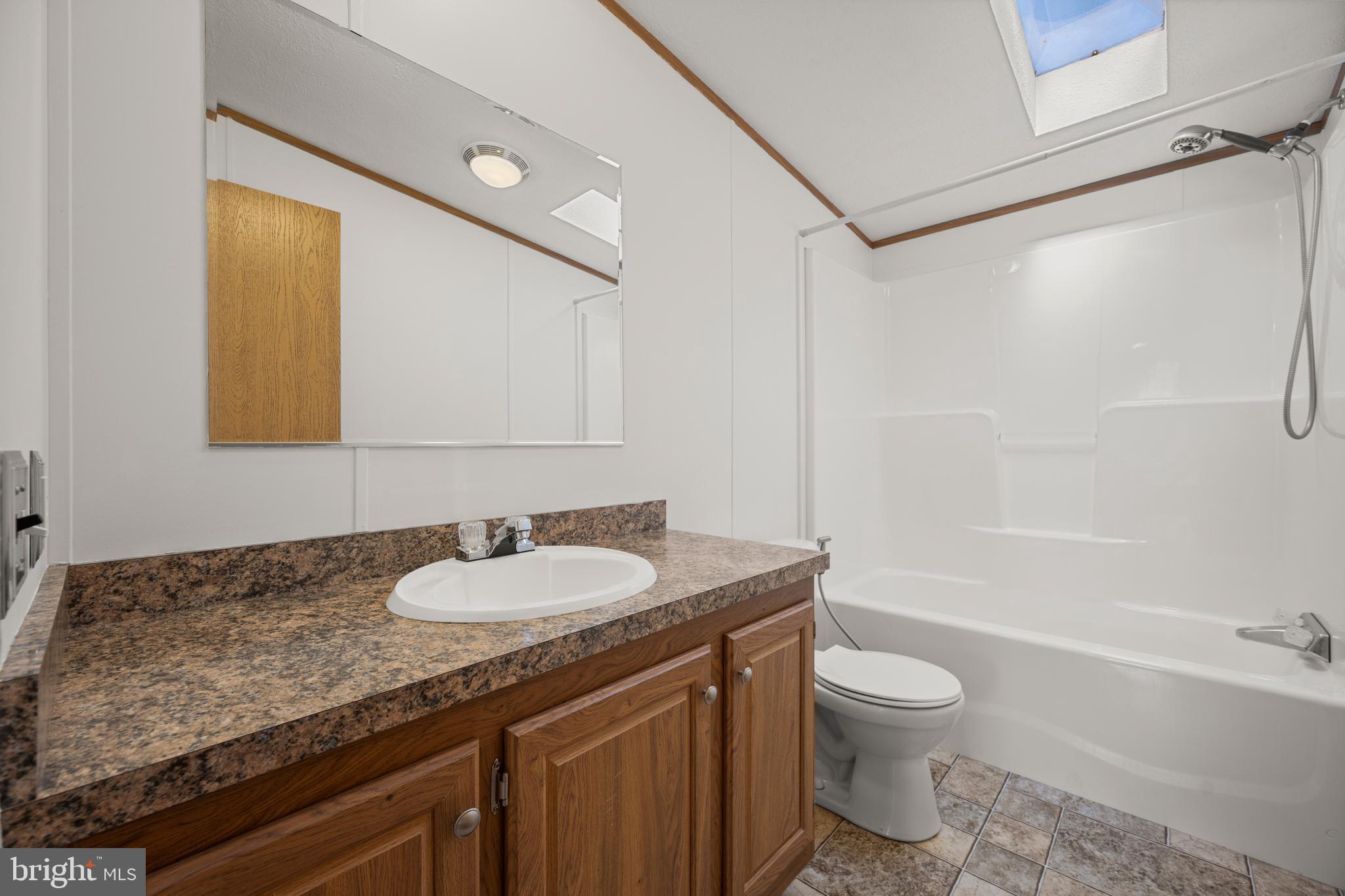 8408 Heartwood Road Jessup, MD 20794 - Photo 24 of 32 a bathroom with a granite countertop sink toilet and shower