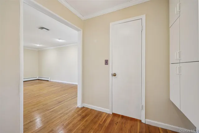 a view of an empty room with wooden floor