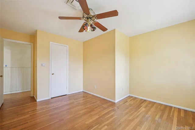 a view of a room with wooden floor and a ceiling fan