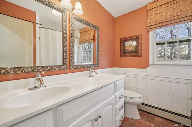 a bathroom with a granite countertop sink mirror vanity and toilet
