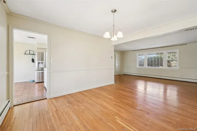 a view of empty room with wooden floor and window
