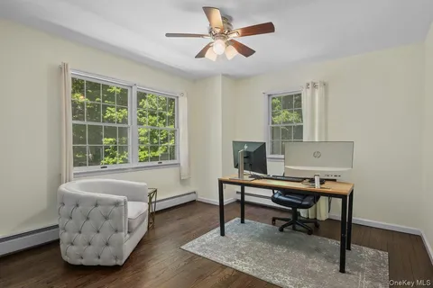 a view of a workspace with furniture and a window