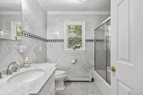 a bathroom with a granite countertop sink a toilet and shower