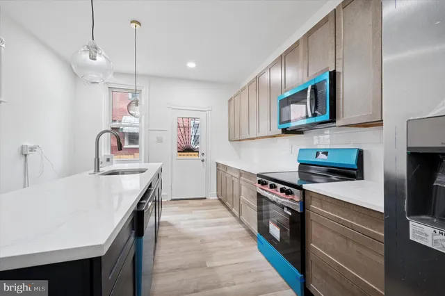 a kitchen with stainless steel appliances granite countertop a kitchen island a stove and a sink