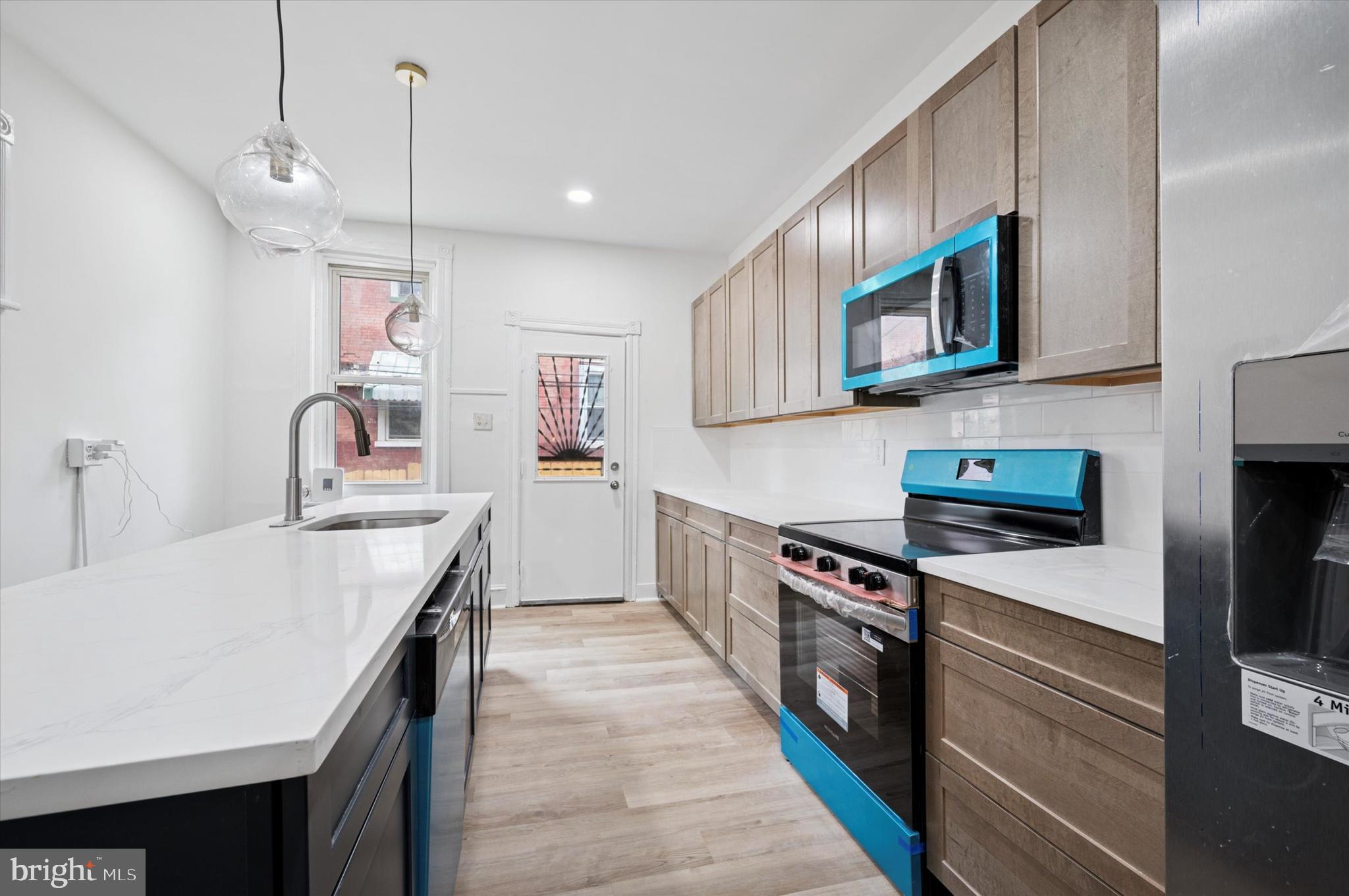 5457 Cedar Avenue Philadelphia, PA 19143 - Photo 13 of 29 a kitchen with stainless steel appliances granite countertop a kitchen island a stove and a sink