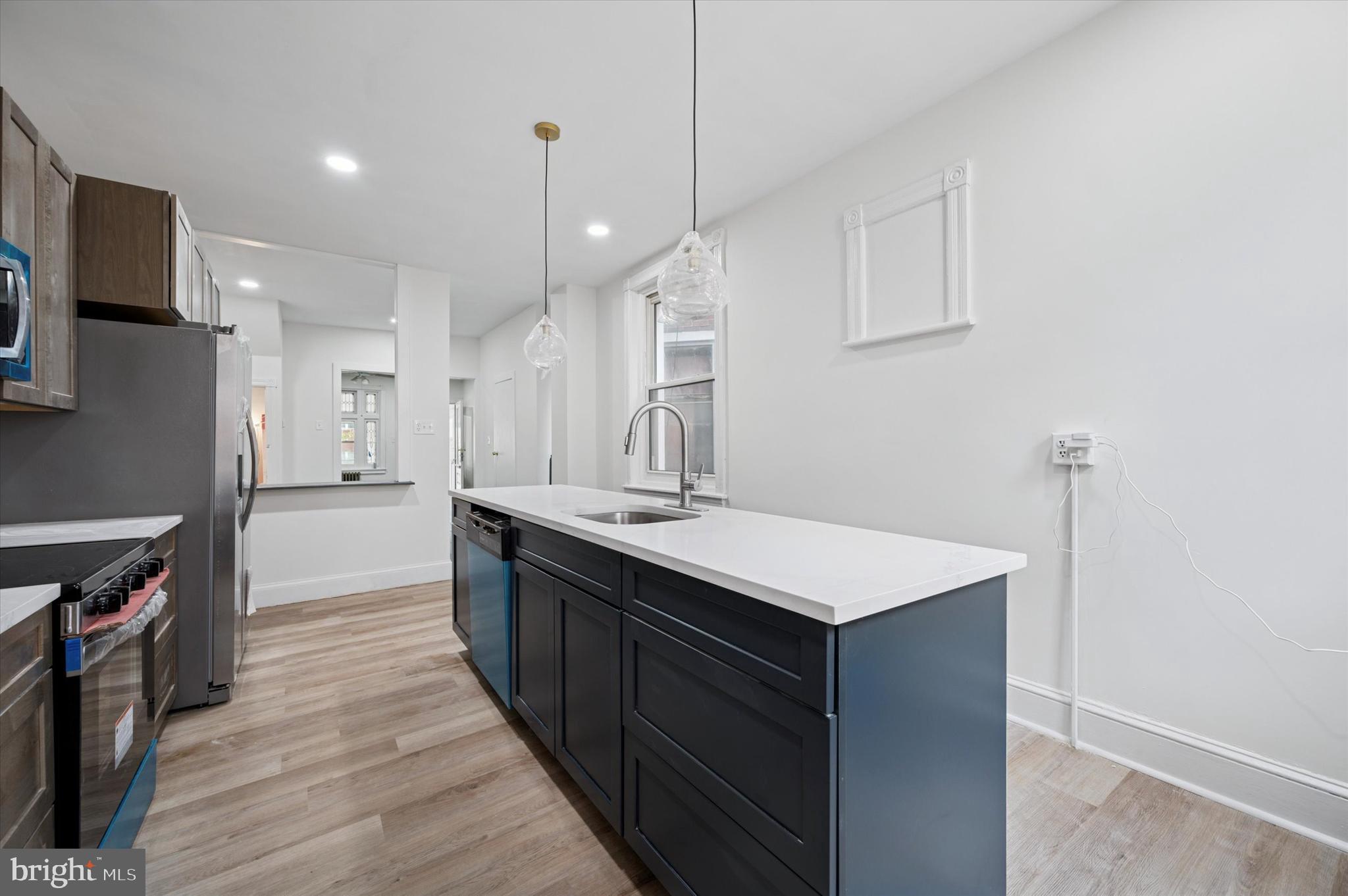 5457 Cedar Avenue Philadelphia, PA 19143 - Photo 14 of 29 a kitchen with a sink a counter space and stainless steel appliances