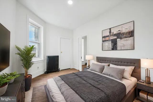 a bedroom with a large bed and a potted plant