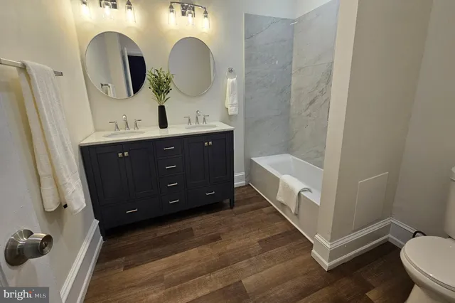 a bathroom with a double vanity sink mirror and toilet