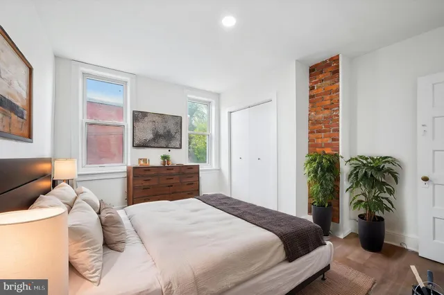 a bedroom with a bed and a potted plant