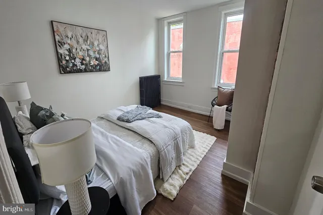 a bedroom with a bed and a painting on the wall
