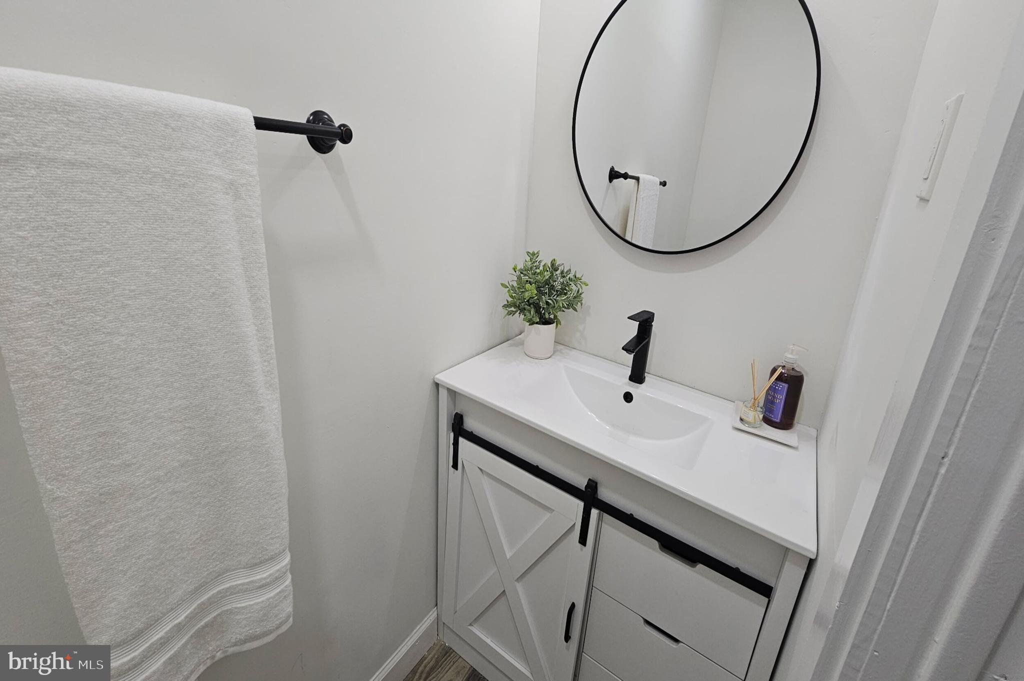 5457 Cedar Avenue Philadelphia, PA 19143 - Photo 29 of 29 a bathroom with a sink and mirror