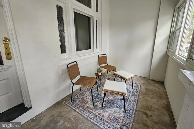 a view of a hallway with chairs and front door