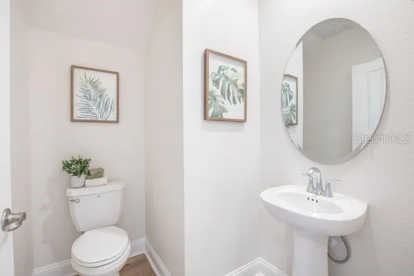 a bathroom with a toilet a sink and mirror