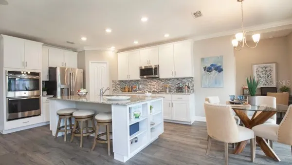 a kitchen with kitchen island granite countertop wooden cabinets and refrigerator