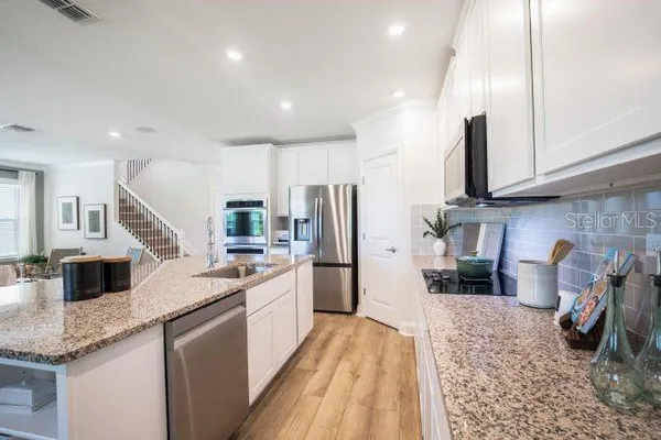 a kitchen with white cabinets and stainless steel appliances