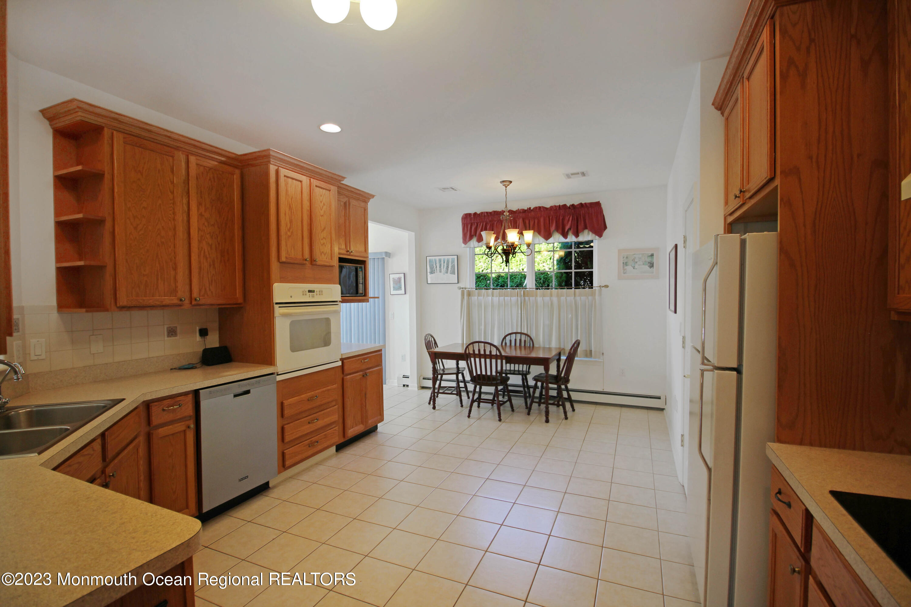 11 Carriage Road Whiting, NJ 08759 - Photo 14 of 35 a kitchen with a dining table chairs and refrigerator