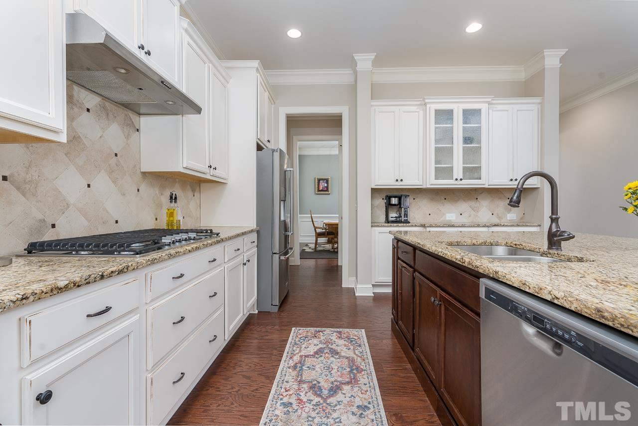 4813 Sunset Fairways Drive Apex, NC 27539 - Photo 15 of 44 a kitchen with granite countertop a sink stove and cabinets