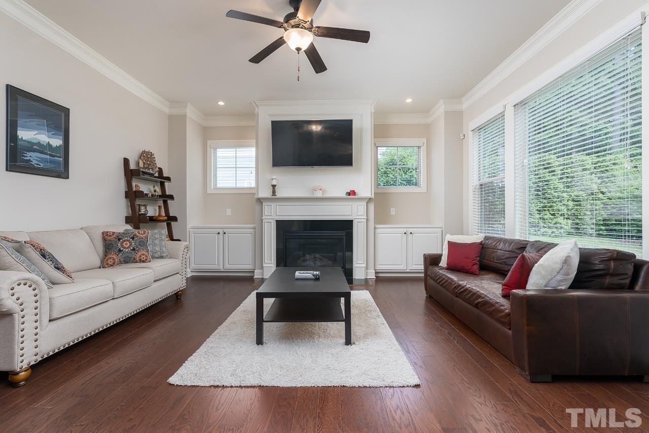 4813 Sunset Fairways Drive Apex, NC 27539 - Photo 18 of 44 a living room with furniture a flat screen tv and a fireplace