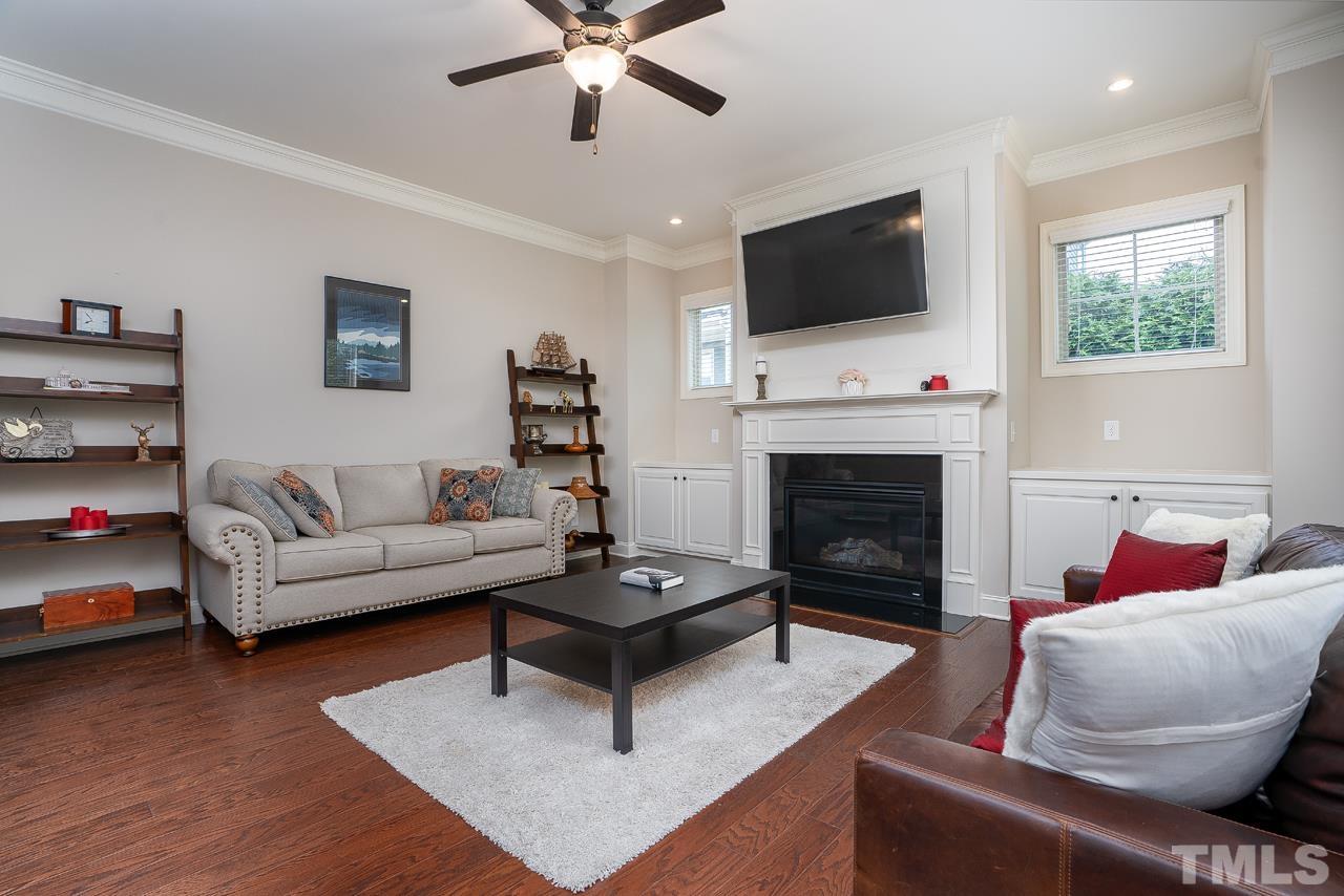 4813 Sunset Fairways Drive Apex, NC 27539 - Photo 19 of 44 a living room with furniture a flat screen tv and a fireplace