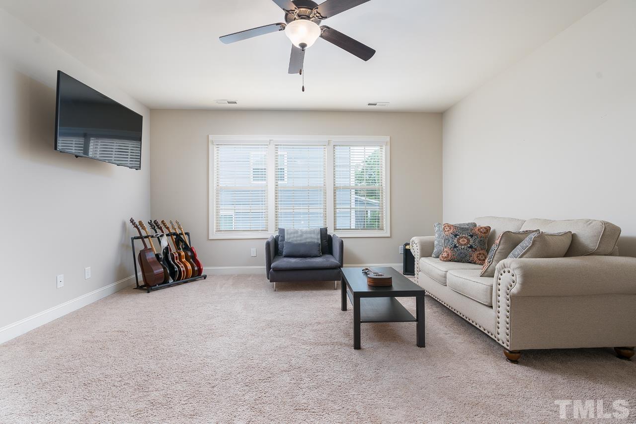 4813 Sunset Fairways Drive Apex, NC 27539 - Photo 20 of 44 a living room with furniture and a flat screen tv